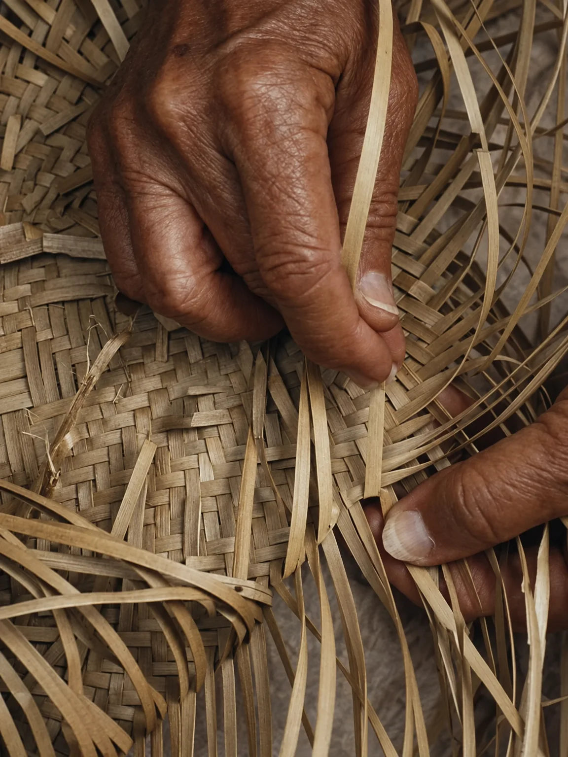 Close-up of hands and traditional bamboo weaving